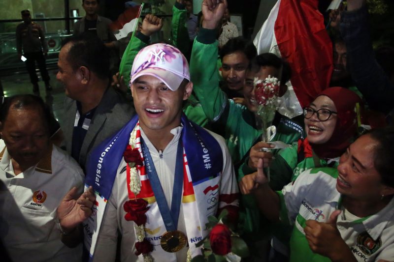 Atlet Angkat Besi Indonesia peraih medali emas di Olimpiade Paris 2024 Rizky Juniansyah mendapat sambutan dari masyarakat setibanya dari Paris di Terminal 3 VIP Bandara Soekarno Hatta, Tangerang, Banten, Selasa (13/8/2024). . ANTARA FOTO/Muhammad Iqbal/foc.