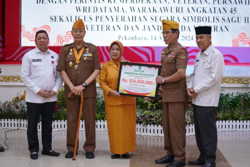 Asisten I Sekretariat Daerah Provinsi Riau, Zulkifli Syukur saat menyerahkan sagu hati secara simbolis kepada veteran disaksikan Ketua Legiun Veteran Republik Indonesia (LVRI) Provinsi Riau, M. Toyyib di Gedung Balai Serindit, Pekanbaru, Rabu(14/08/2024). ANTARA/HO-HUmas Pemerintah Provinsi Riau.