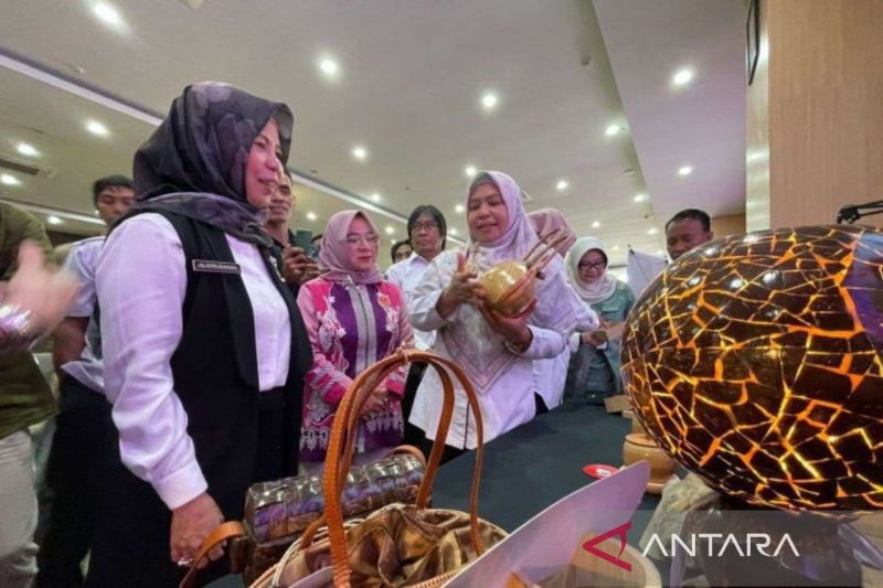 Ketua Harian Dekranasda NTB, Hj Nuryanti (tengah), menunjukkan salah satu hasil kerajinan lokal dalam acara pembukaan Dekranasda Awards 2024. (ANTARA/Disperin NTB).