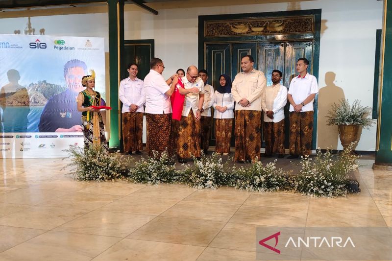 Asisten Deputi Bidang Tanggung Jawab Sosial dan Lingkungan Kementerian BUMN Edi Eko Cahyono memasangkan rompi kepada salah satu relawan bakti BUMN di Solo, Jawa Tengah, Rabu (14/8/2024). ANTARA/Aris Wasita
