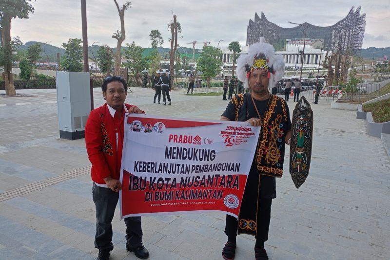 Warga Sampit Kalimantan Tengah Wahyudi (kiri) bersama dengan pekerja kemenko 1 IKN Dewo di depan Istana Negara IKN, Sabtu (17/8/2024). ANTARA/Rangga Pandu Asmara Jingga
