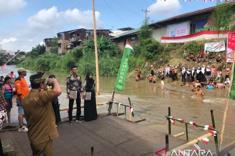 Warga Kampung Aur, Kecamatan Medan Maimun, Kota Medan, Sumatera Utara, menggelar upacara HUT Kemerdekaan ke-79 RI dengan cara yang unik yakni melakukannya di tengah-tengah Sungai Deli, Sabtu. (ANTARA/Dina Purnama)