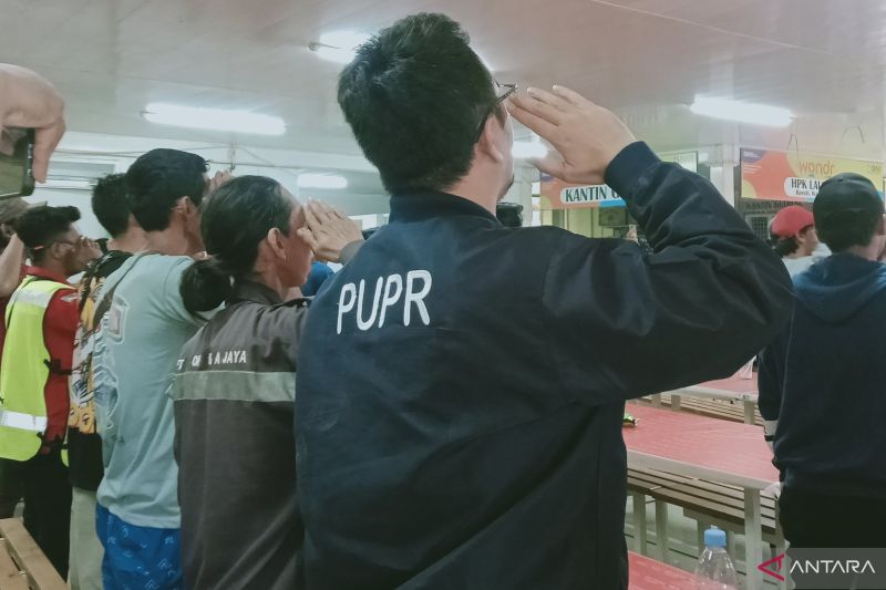 Pekerja konstruksi IKN berdiri tegak hormat bendera ketika menyaksikan pengibaran bendera upacara kemerdekaan Indonesia di Istana Garuda Kota Nusantara melalui televisi di Kantin HPK, Sabtu (17/8/2024) (ANTARA/Nyaman Bagus Purwaniawan)
