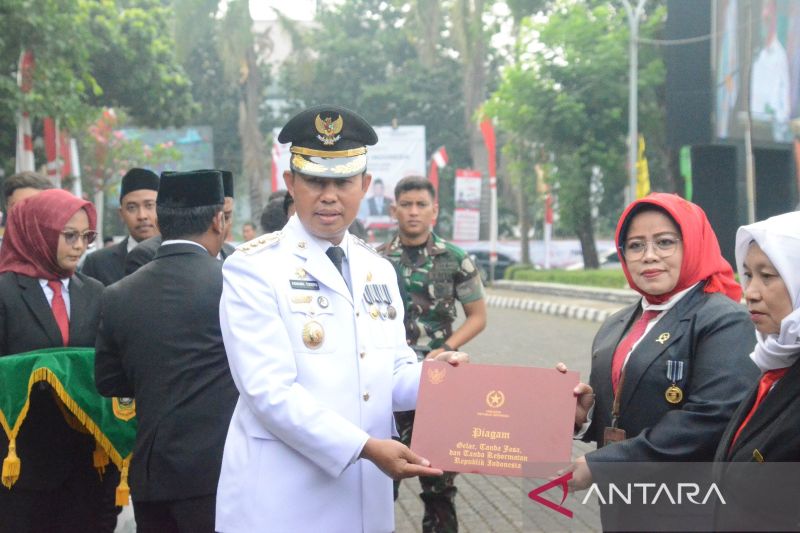 Penjabat Bupati Bogor Asmawa Tosepu menyerahkan penghargaan usai upacara kemerdekaan di Lapangan Tegar Beriman, Cibinong, Kabupaten Bogor, Jawa Barat, Sabtu (17/8/2024). (ANTARA/HO-Humas Pemkab Bogor)