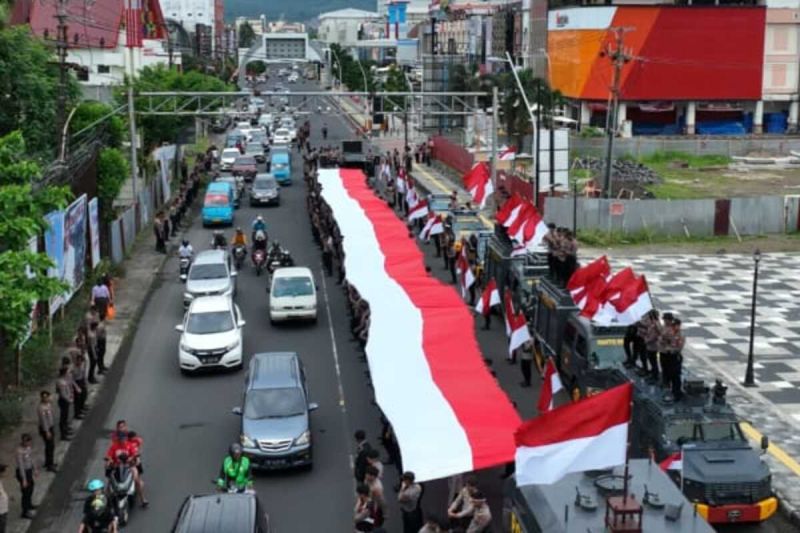 Personel Ditsamapta Polda Sulut bentangkan bendera Merah Putih berukuran 79 Meter. ANTARA/HO-Humas Polda Sulut (1)