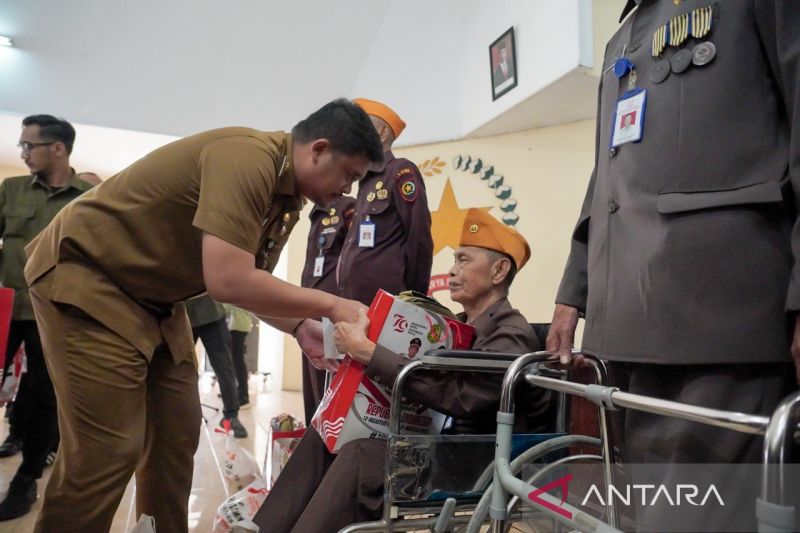 Wali Kota Medan Bobby Nasution (kiri) menyerahkan bantuan tali asih kepada para veteran di Kantor Legiun Veteran Republik Indonesia Kota Medan, Senin (19/8/2024). (ANTARA/HO-Diskominfo Kota Medan)