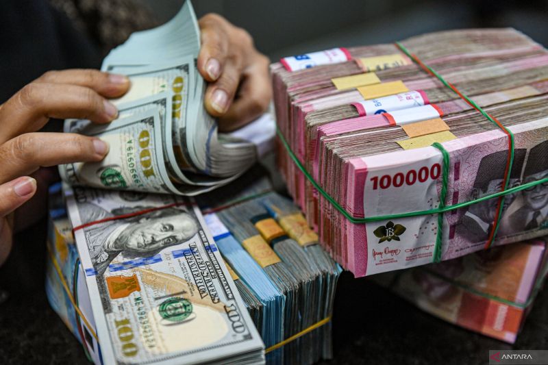 Petugas menghitung uang pecahan dolar AS dan rupiah di gerai penukaran mata uang asing VIP (Valuta Inti Prima) Money Changer, Jakarta, Jumat (1/3/2024). Kementerian Keuangan (Kemenkeu) mencatatÊutangÊpemerintah naik menjadi Rp8.253,09 triliun per Januari 2024, jumlah utang tersebut naik sebesar Rp108,4 triliun dibandingkan utang di Desember 2023, yakni sebesar Rp8.144,69 triliun. ANTARA FOTO/Muhammad Adimaja/rwa (ANTARA FOTO/MUHAMMAD ADIMAJA)