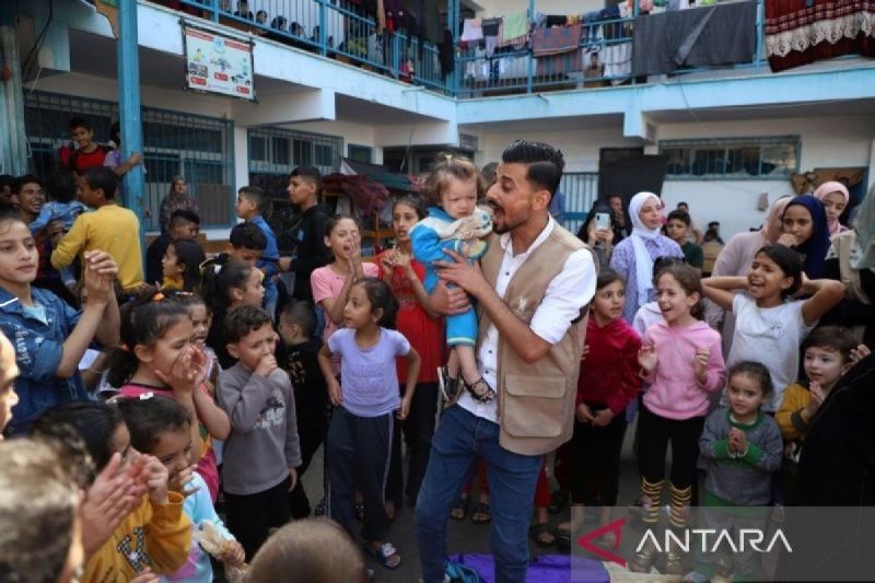Arsip - Seorang sukarelawan berinteraksi dengan anak-anak selama kegiatan stimulasi dan bantuan psikologis di sebuah sekolah yang berafiliasi dengan Badan Bantuan dan Pekerjaan PBB untuk Pengungsi Palestina (UNRWA) di kota Khan Younis, Jalur Gaza selatan, Palestina (8/11/2023). (ANTARA/Xinhua/Rizek Abdeljawad/aa.)