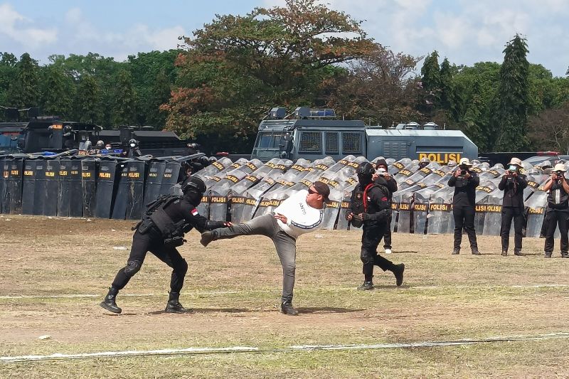 Para personel Kepolisian Daerah Bali memperagakan aksi melawan pelaku penyanderaan KPU saat simulasi Sistem Pengamanan Kota (Sispamkota) di Lapangan Niti Mandala, Renon, Denpasar, Kamis (22/8/2024). ANTARA/Rolandus Nampu.