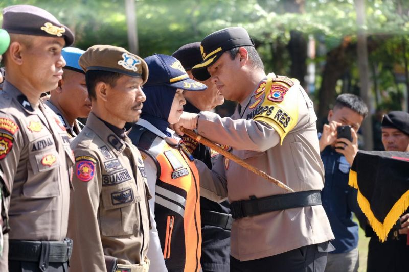Kapolres Gowa AKBP RTS Simanjuntak melakukan pemasangan pita kepada salah seorang personel pada pelaksanaan Apel Gelar Operasi Mantap Praja 2024 menyambut Pilkada Serentak di Gowa, Kamis (22/8/2024). ANTARA/HO/Pemkab Gowa