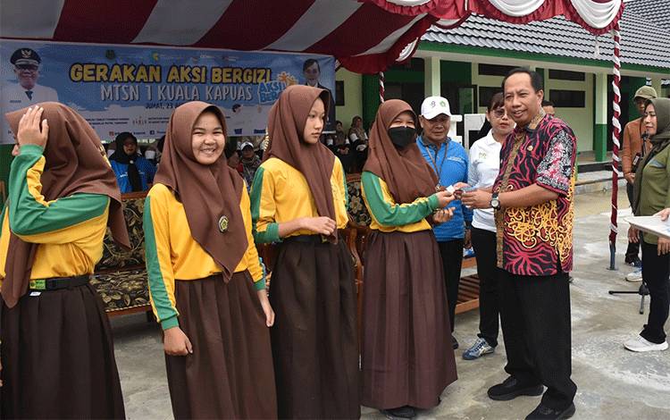 Asisten III Setda Kapuas, Ahmad M Saribi saat menyerahkan secara simbolis tablet tambah darah pada Gerakan Aksi Bergizi di MTSN 1, Jumat, 23 Agustus 2024. (FOTO: IST)