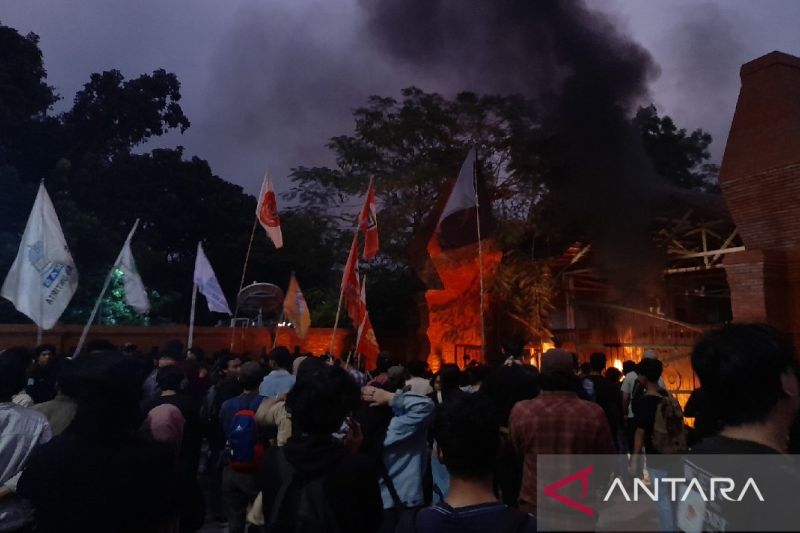 Ratusan mahasiswa dari berbagai perguruan tinggi di Provinsi Banten menggerudung dan membakar pagar Kantor DPRD Banten di Jalan Sukajaya, Kecamatan Curug, Kota Serang, Banten, Jumat (23/8/2024). (ANTARA/Desi Purnama Sari)