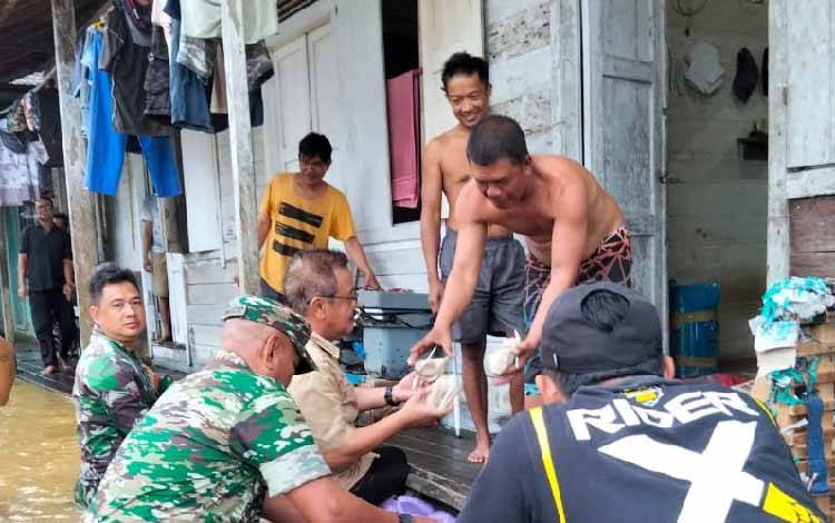 Pj Bupati Gunung Mas Herson B Aden saat menyerahkan nasi bungkus kepada warga di Kecamatan Tewah, Jumat, 23 Agustus 2024. (FOTO: IST)