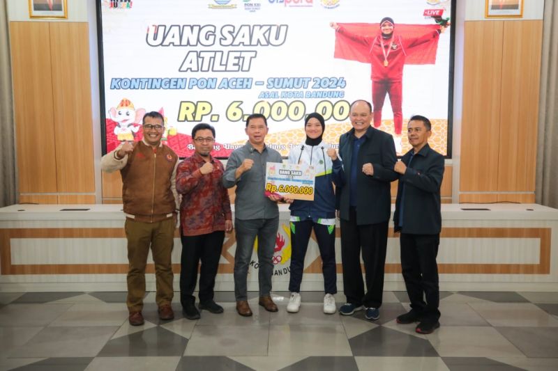 Penjabat Sekretaris Daerah Kota Bandung Dharmawan (tengah) saat memberikan uang saku kepada salah satu atlet kontingen Provinsi Jawa Barat di Kota Bandung, (24/8/2024). (ANTARA/HO-Pemkot Bandung)