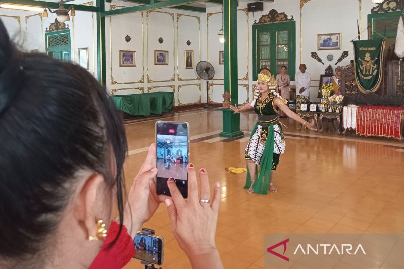 Seorang pengunjung saat mengabadikan momen pertunjukan seni tari yang dipentaskan di Keraton Kacirebonan, Kota Cirebon, Jawa Barat, Minggu (25/8/2024). (ANTARA/Fathnur Rohman)