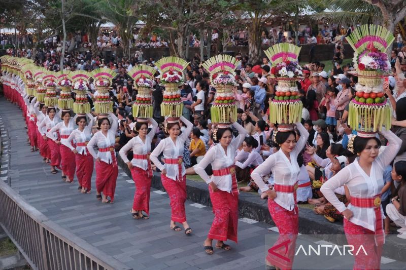 Sejumlah perempuan Bali menjunjung gebogan atau sesajen berisi buah, kue, bunga dan hiasan janur saat parade mapeed pada pembukaan Tanah Lot Art & Festival 2024, di objek wisata Tanah Lot, Tabanan, Bali, Jumat (23/8/2024). ANTARA FOTO/Nyoman Hendra Wibowo