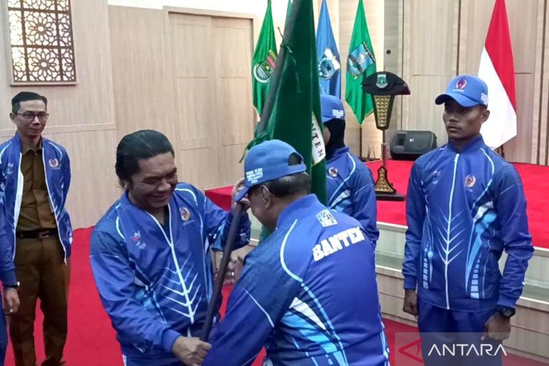 Pj Gubernur Banten Al Muktabar (kiri) di Serang, Senin (26/8/2024) menyerahkan pataka kepada perwakilan Kontingen Banten ke PON 2024 Aceh-Sumut. ANTARA/Mulyana