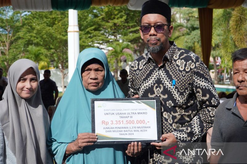 Anggota Badan Baitul Mal Aceh Mukhlis Sya'ya saat menyerahkan secara simbolis bantuan usaha ultra mikro kepada mustahik di Kantor Baitul Mal Aceh. (ANTARA/HO-Baitul Mal Aceh)