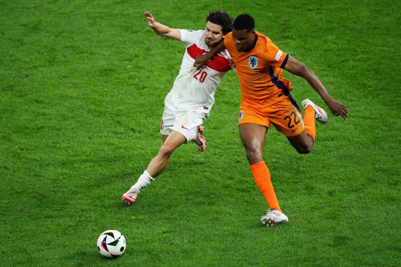 Pemain belakang Turki Ferdi Kadioglu (kiri) berduel dengan bek Belanda Denzel Dumfries saat pertandingan perempat final Euro 2024 kedua tim di Olympiastadion Berlin, Berlin, pada 6 Juli 2024. (Photo by Ronny HARTMANN / AFP) (AFP/RONNY HARTMANN)