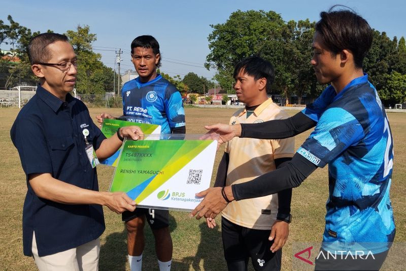 Kepala BPJS Ketenagakerjaan Cabang Kudus Mulyono Adi Nugroho menyerahkan kepesertaan jaminan sosial ketenagakerjaan secara simbolis kepada pemain Persiku Kudus Renshi Yamaguchi beserta Jajang Mulyana dan asisten pelatih Syaiful Anas di Lapangan Desa Bacin, Kecamatan Bae, Kabupaten Kudus. (ANTARA/Akhmad Nazaruddin Lathif)