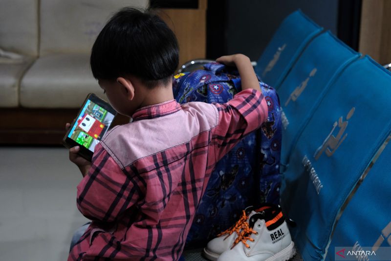 Ilustrasi anak pekerja migran Indonesia tengah asyik menonton film dari ponsel pintar sebelum keberangkatan ke bandara di Balai Pelayanan Pelindungan Pekerja Migran Indonesia (BP3MI) Kalimantan Barat di Pontianak, Kalimantan Barat, Rabu (3/8/2022). ANTARA FOTO/Jessica Helena Wuysang/wsj.