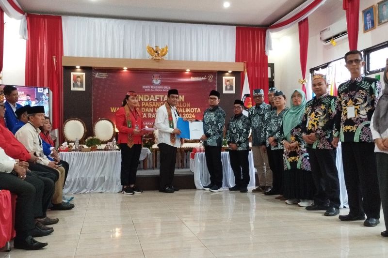 Bakal calon Wali Kota Palangka Raya, Rojikinnor (baju putih) saat menyerahkan berkas pendaftaran kepada Ketua KPU Kota Palangka Raya, Joko Anggoro, di aula KPU Kota Palangka Raya, Kamis (29/8/2024). (ANTARA/Rendhik Andika)