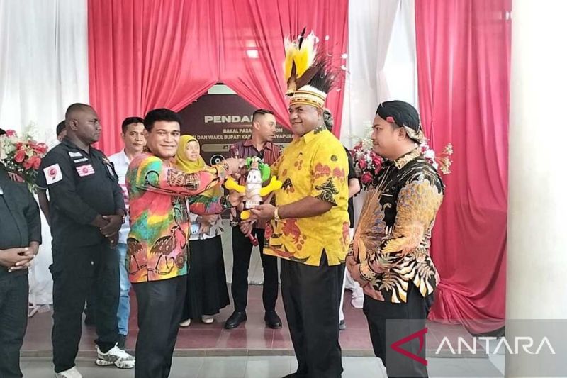 Ketua KPU Kabupaten Jayapura Efra J Tunya saat menyerahkan cendera mata kepada Bapaslon Bupati dan Wabup Jayapura Ted Y Mokay-Supardi saat melengkapi pemberkasan pendaftaran pada hari ketiga, Kamis. ANTARA/Yudhi Efendi.