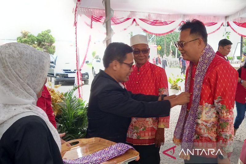Sekretaris KPU Kabupaten Bangka Barat Jajat Sudrajat mengalungkan selendang sebagai bentuk penghormatan kepada bakal calon peserta Pilkada 2024, Markus-Yus Derahman. (ANTARA/ Donatus Dasapurna)