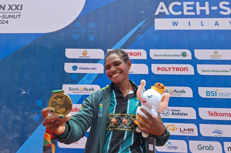Atlet dayung Papua Pegunungan, Stevani Maysche Ibo memamerkan medali emas canoeing nomor kayak 1000 m putri PON Aceh-Sumut 2024 di Waduk Keuliling, Aceh Besar, Rabu (4/9/2024). (ANTARA/FAJAR SATRIYO)
