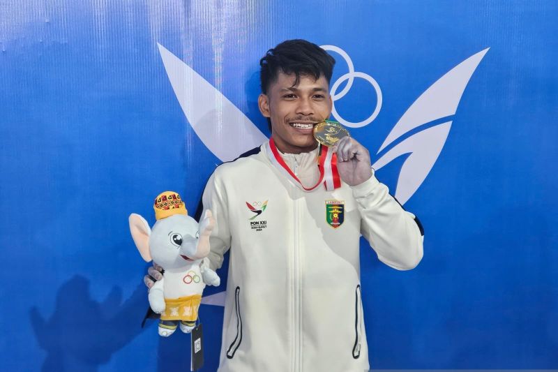 Pemenang medali emas cabang angkat besi kelas 55 kilogram putra PON Aceh-Sumatera Utara 2024 Muhammad Husni asal Lampung, berpose setelah upacara penghargaan pemenang di GOR Seuramo, Banda Aceh, Rabu (4/9/2024). (ANTARA/RAUF ADIPATI)