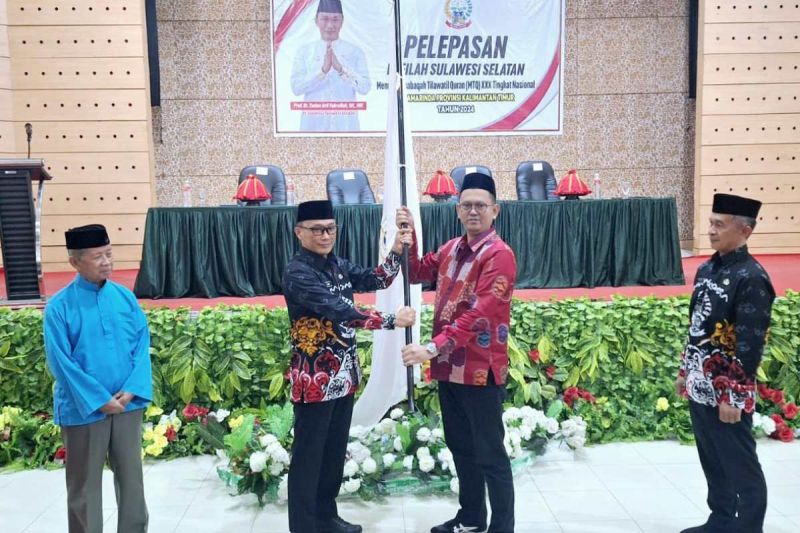 Penjabat Gubernur Sulsel Zudan Arif Fakrulloh (kiri) menyerahkan bendera kepada pimpinan Kafilah Sulsel yang akan bertanding di MTQ Nasional, Kalimantan Timur, Kamis (5/9/2024). ANTARA/HO/Kemenag Sulsel
