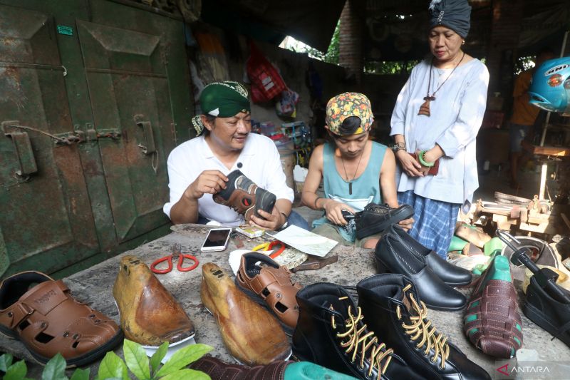 Visitors observe the leather shoe-making process at a home industry in Gedangsewu Village, Kediri, East Java. Photo by ANTARA FOTO/Prasetia Fauzani.