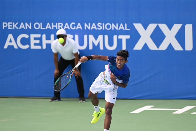 Petenis Aceh Muhammad Zaid Aulia melakukan servis ke arah lawannya petenis Sumatera Utara Muhammad Rizki Ananda dalam pertandingan penyisihan tenis putra PON XXI Aceh-Sumut 2024 di GOR Stadion Harapan Bangsa, Banda Aceh, Aceh, Minggu (8/9/2024). Muhammad Zaid Aulia menang dengan skor 7-5 dan 6-0. ANTARA FOTO/Arnas Padda/aww. (ANTARA/ARNAS PADDA)
