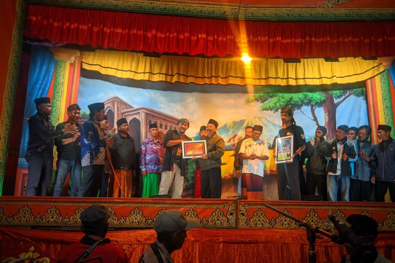 Ketua DeKaJe Eko Suwargono memberikan piagam penghargaan kepada Kepala Desa Mangaran, Kecamatan Ajung yang telah menanggap kesenian rakyat di desanya pada Sabtu (7/9/2024). (ANTARA/HO-DeKaJe)
