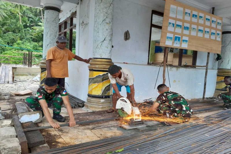 Personel Satgas Pamputer Posad Marampit membantu warga dalam pembangunan gereja. ANTARA/HO-Kodim Talaud.