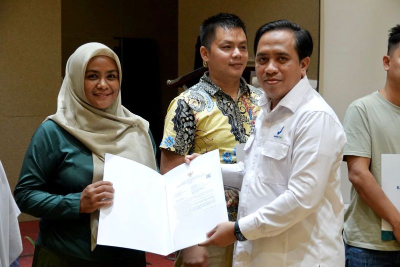 Kepala Balai POM Batam Musthofa Anshori (kanan) menyerahkan dokumen NIE kepada peserta sosialisasi dan desk register di Batam, Jumat (30/8/2024). (ANTARA/HO-Balai POM Batam)