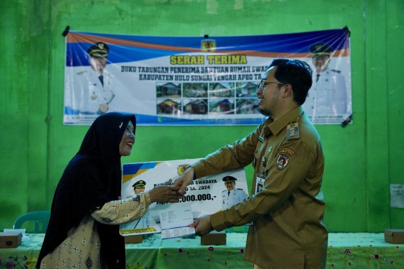 Bupati HST Aulia Oktafiandi menyerahkan secara simbolis bantuan rumah swadaya kepada salah satu penerima manfaat di Gedung Serbaguna Pantai Hambawang Barat, Hulu Sungai Tengah, Kalimantan Selatan, Selasa (10/9/2024). ANTARA/HO-Pemkab HST
