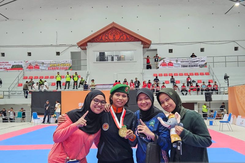 Atlet hapkido Sulawesi Barat Devi Safitri (kedua dari kiri) berpose bersama teman-temannya setelah memenangi medali emas nomor kelas 59-63 kilogram putri Pekan Olahraga Nasional (PON) XXI Aceh-Sumatera Utara 2024 di GOR KONI, Banda Aceh, Selasa (10/9/2024). (ANTARA/RAUF ADIPATI)