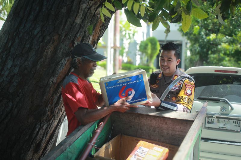 Personel Satlantas Polresta Palu memberikan bantuan sembako kepada warga yang membutuhkan di Palu, Rabu (11/9/2024). (ANTARA/HO-Humas Polresta Palu)