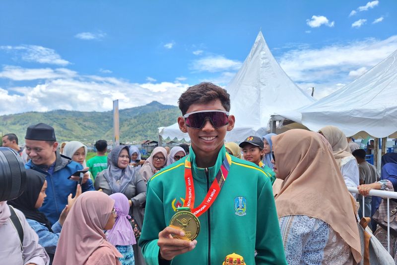 Atlet Jawa Timur, Muhammad Noval Ashidiq seusai menerima medali emas di nomor triathlon standar putra Pekan Olahraga Nasional (PON) XXI Aceh-Sumut 2024 di Danau Lut Tawar, Takengon, Rabu (11/09/2024). (ANTARA/FAJAR SATRIYO)