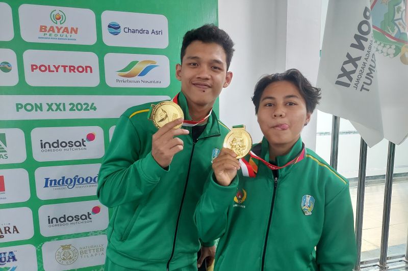 Atlet Jawa Timur Aldinsyah Putra Rafi (kiri) dan Gladies Lariesa Garina Hagakore memamerkan emas yang diraih pada PON 2024 Aceh-Sumatera Utara di Kolam Renang Selayang, Medan, Sumatera Utara, Rabu (11/9/2024). (ANTARA/Muhammad Ramdan)
