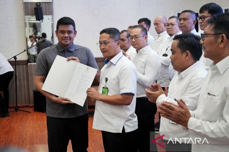 Wali Kota Medan Bobby Nasution (kiri) menyerahkan SK Wali Kota Medan kepada pengurus Lembaga Kerja sama Tripartit dan Dewan Pengupahan Kota Medan 2024-2027, di Balai Kota Medan, Rabu (11/9/2024). (ANTARA/HO-Diskominfo Kota Medan)