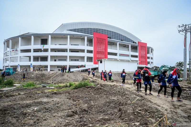 Sejumlah pemain voli PON XXI Aceh-Sumut melewati jalan berlumpur di GOR Bola Voli Indoor Sumut Sport Center, Kabupaten Deli Serdang, Sumatera Utara, Selasa (10/9/2024). Pertandingan voli indoor yang semula dijadwalkan Selasa (10/9) diundur menjadi Rabu (11/9) karena GOR belum siap dan akses jalan berlumpur. ANTARA FOTO/Rivan Awal Lingga/nz