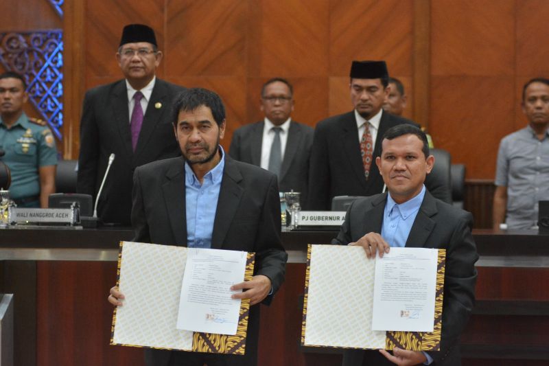 Pasangan calon Gubernur dan Wakil Gubernur Aceh Mualem-Dek Fad memperlihatkan surat pernyataan kesediaan menjalankan butir-butir MoU Helsinki, di gedung DPRA, Banda Aceh, Kamis (12/9/2024) (ANTARA/HO/Humas DPRA)