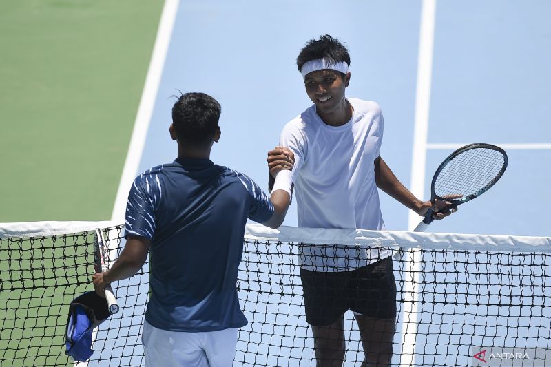 Petenis Jawa Timur M Rifqi Fitriadi berjabat tangan dengan petenis Aceh M Gunawan Trimuswantara usai bertanding pada babak perempat final tenis beregu putra PON XXI Aceh-Sumut 2024 di Lapangan Tenis Harapan Bangsa, Banda Aceh, Aceh, Kamis (12/9/2024). (ANTARA/Aprillio Akbar)
