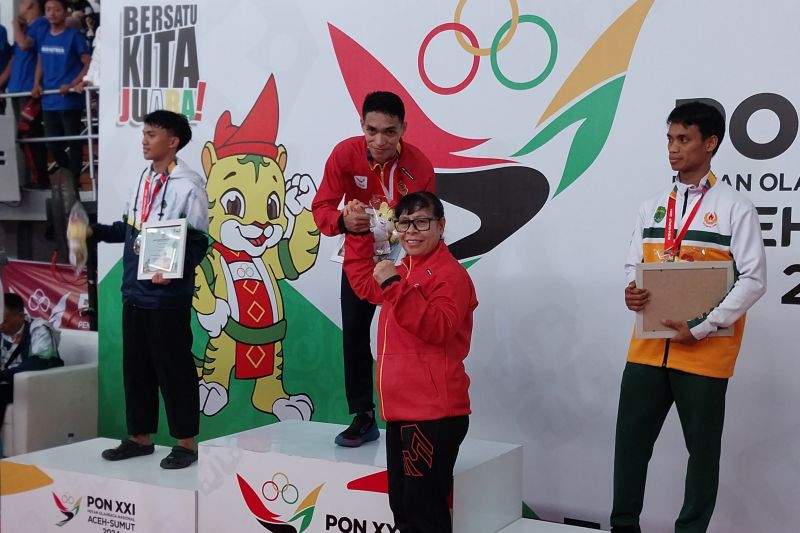 Pesilat asal Nusa Tenggara Timur Muhammad Zaki Zikrillah Prasong (tengah) berfoto saat menerima medali emas setelah memenangkan laga final kategori tanding kelas B +50 s/d 55kg putra cabang pencak silat PON Aceh-Sumut 2024 di GOR Veteran, Medan, Jumat (13/9/2024). (ANTARA/Aloysius Lewokeda)