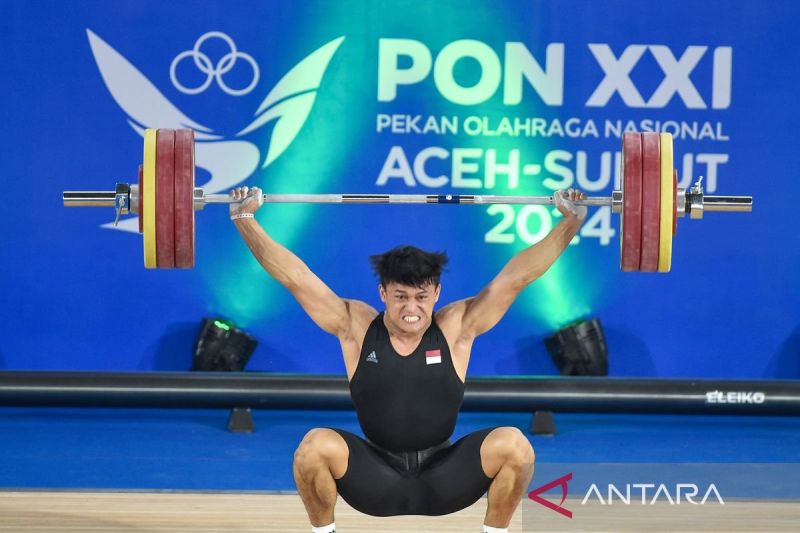 Lifter Banten Rizki Juniansyah melakukan angkatan clean and jerk saat angkat besi kelas 89 kilogram putra PON XXI Aceh-Sumut 2024 di GOR Seuramoe Angkat Besi Harapan Bangsa, Banda Aceh, Sabtu (7/9/2024). ANTARA FOTO/Budi Candra Setya/tom.