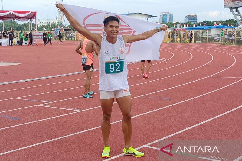 Atlet cabang olahraga atletik Wahyudi Putra, memegang bendera kontingen DKI Jakarta, usai memastikan diri merebut emas nomor 1.500 meter putra di Stadion Madya Atletik Sumut Sport Center, Kabupaten Deli Serdang, Sumatera Utara, Sabtu (14/9/2024). ANTARA/Donny Aditra