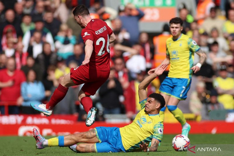 Pesepak bola Liverpool Andrew Robertson (kiri) berebut bola dengan pesepak bola Nottingham Forest Morgan Gibbs-White (bawah) dalam laga lanjutan Liga Inggris, di Stadion ?????Anfield, Liverpool, Inggris, Sabtu (22/4/2023). ANTARA FOTO/Reuters-Phil Noble/hp.