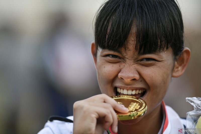Pesepak bola putri Jawa Barat yang juga bermain di liga Jepang Helsya Maeisyaroh mengigit medali emas yang diraihnya usai pertandingan final sepak bola putri PON XXI Aceh-Sumut antara DKI Jakarta melawan Jawa Barat di Stadion Mini Pancing, Deli Serdang, Sumatera Utara, Sabtu (14/9/2024). ANTARA FOTO/Iggoy el Fitra/nz